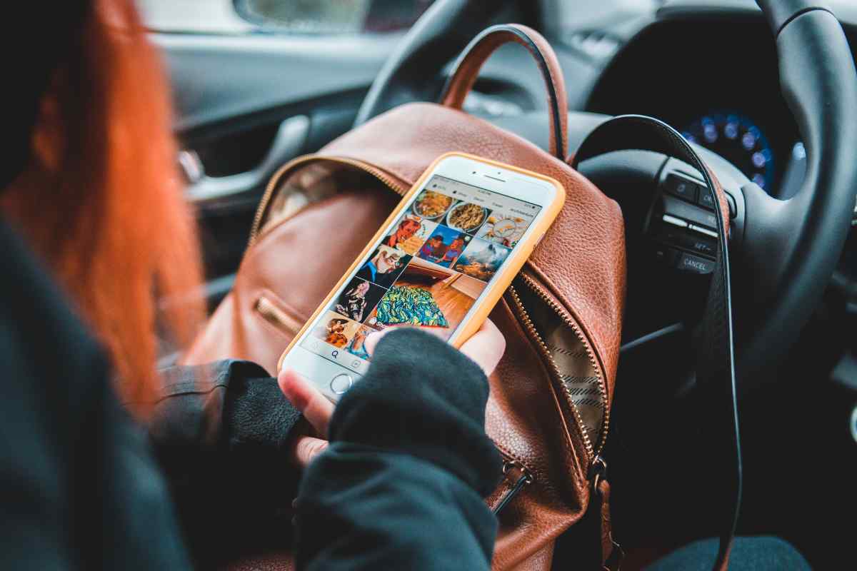 donna guarda lo smartphone mentre guida